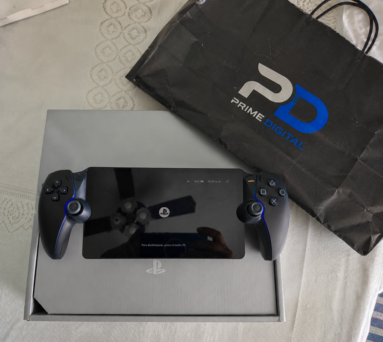 PlayStation Portal junto a su caja y una bolsa de Prime Digital